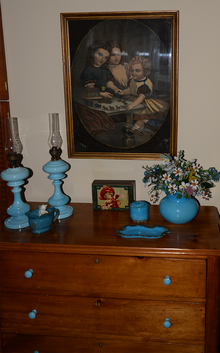 Antique pine chest with blue milkglass kerosene lamps and milkglass pulls on the chest.