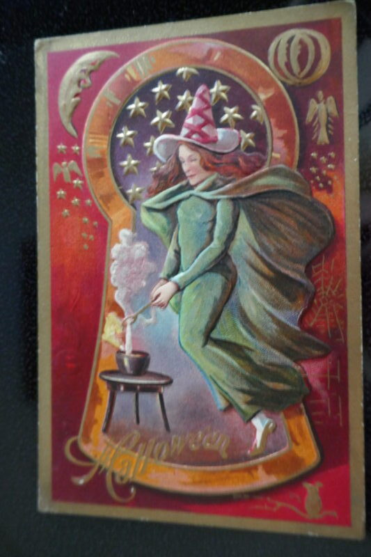 witch in a key hold at cauldron antique postcard