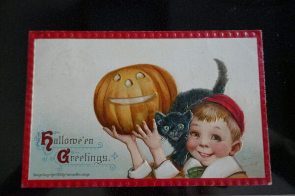 Child holding a pumpkin with cat on his shoulder antique postcard